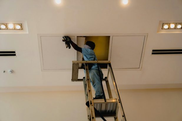 Technicien qui nettoie une bouche de ventilation